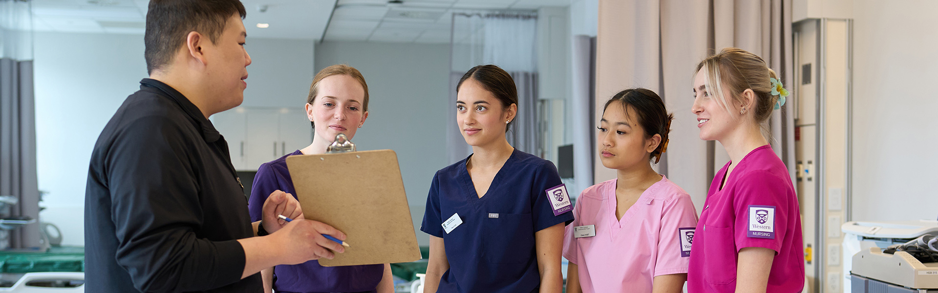 A nursing professor teaching a group of students in the clinical skills lab.