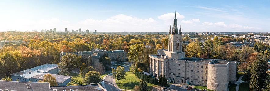 A student tending to plants in an indoor plant enclosure.