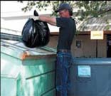 Person placing garbage in dumpster