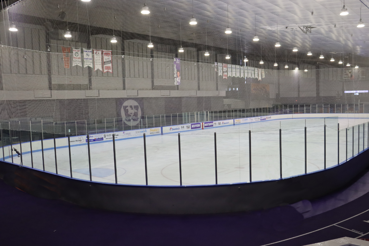 A large hockey arena, with the Western Mustangs' logo in the background.
