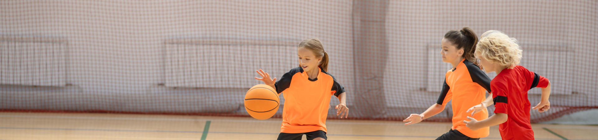 Children playing sports in a gym.