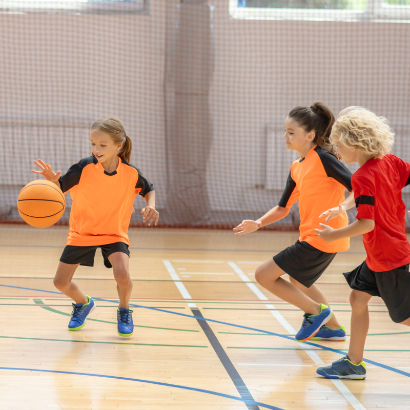 Children playing sports in a gym.