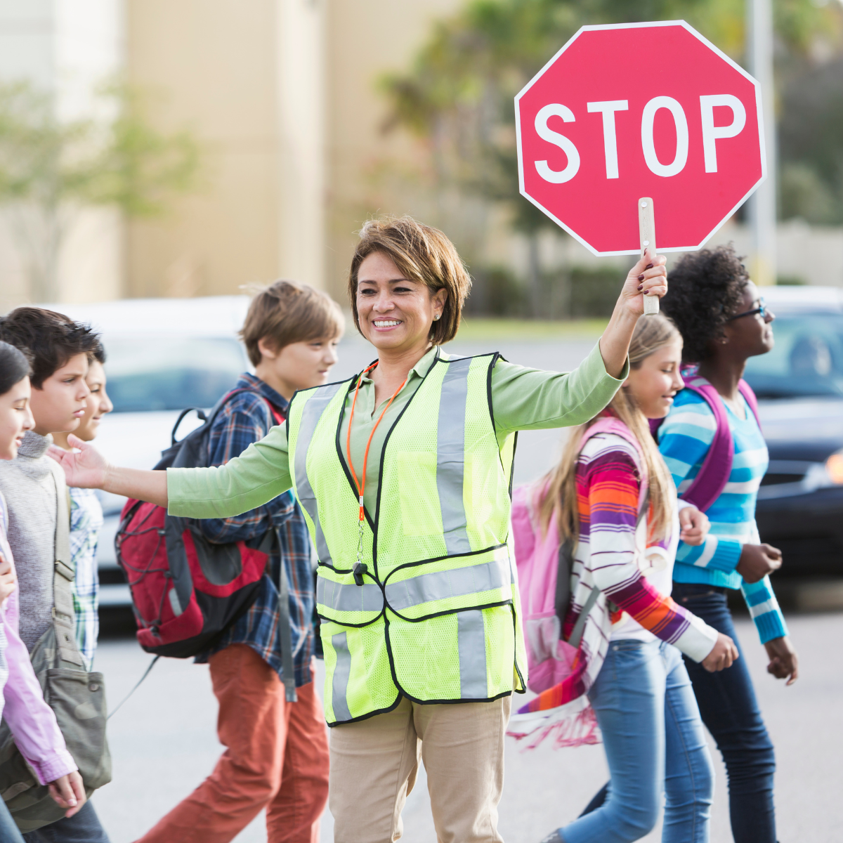 A crossing guard stops traffic for students.