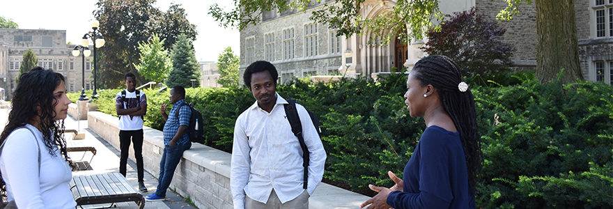 CAYSC members speaking with each other, three in the foreground and two in the background, in front of University College