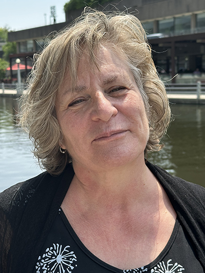 A portrait of a woman in front of a body of water