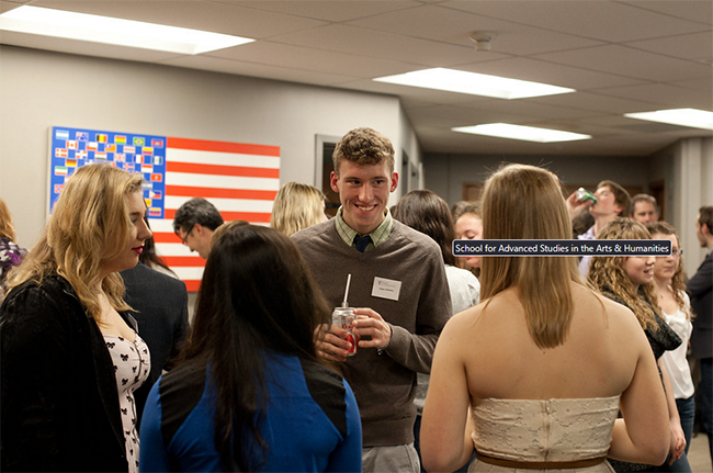 A photograph of students gathered at an indoor reception