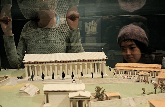 A photograph of students looking at a display of Classical architectural models