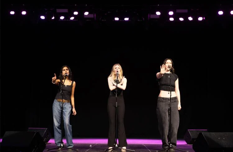 Three performers on stage, mid-scene