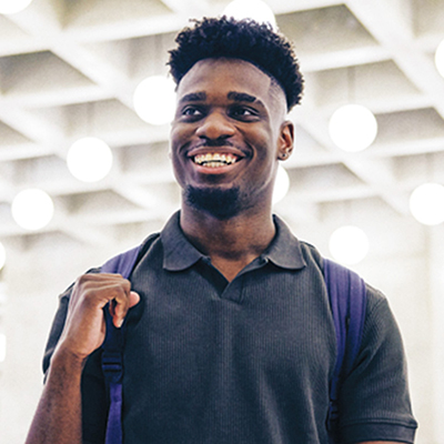 A male student is photographed against a backdrop of lights