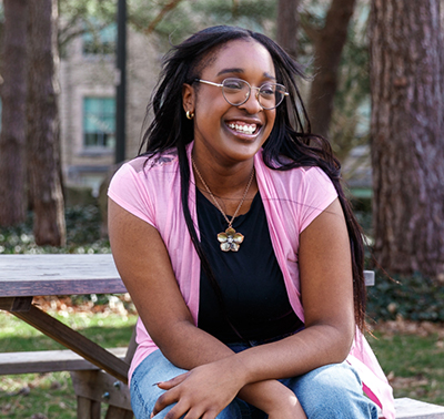 A photograph of a woman sitting outside