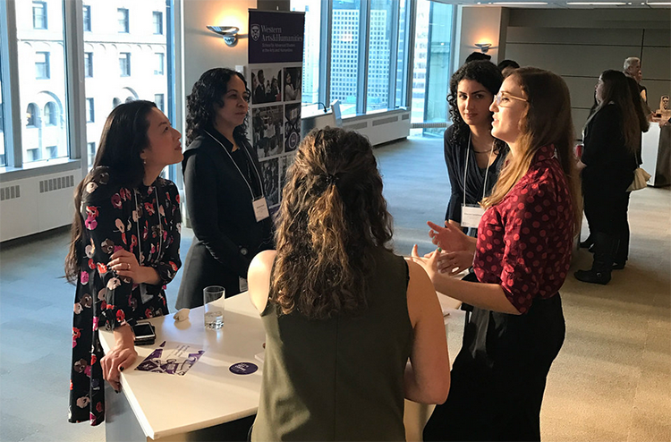 Students and professionals gather and network in a sunlit room