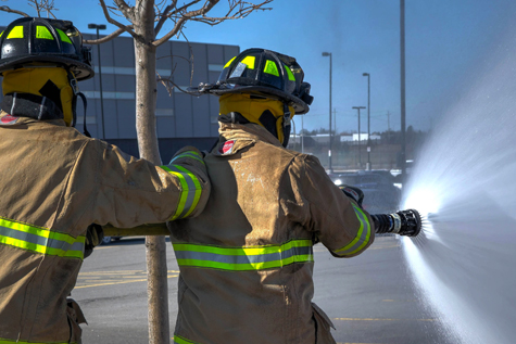 Two firefighters using a hose 