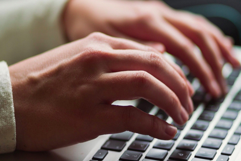 Person's hands on laptop keyboard 