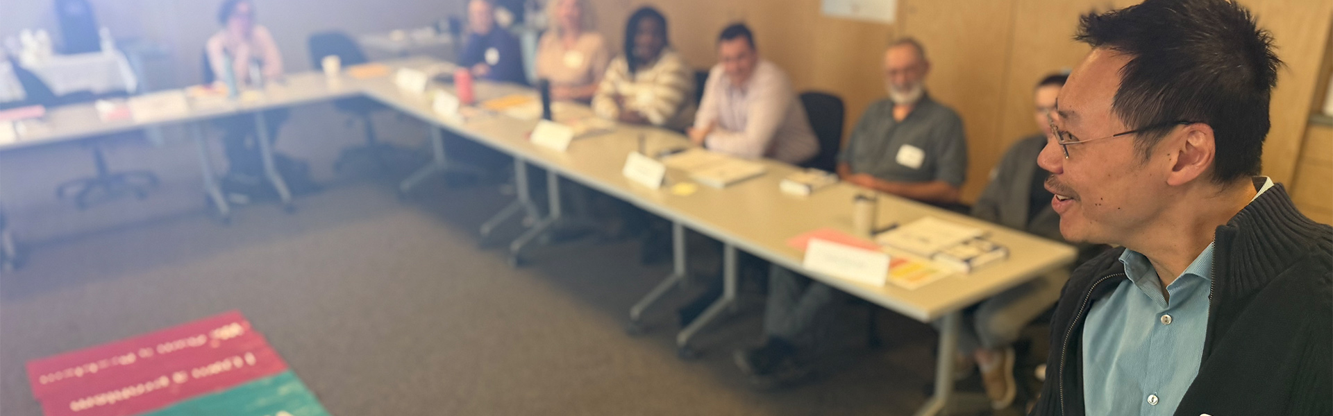 A faculty members presents at the front of a room during a leadership learning session.