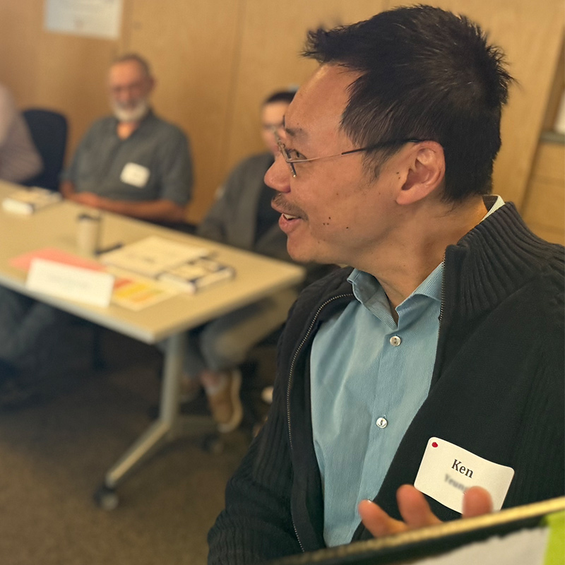 A faculty members presents at the front of a room during a leadership learning session.