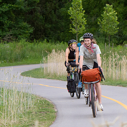 A faculty member and students walk across campus.
