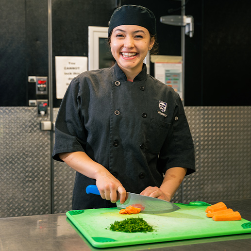 A chef prepares a meal on a cutting board.