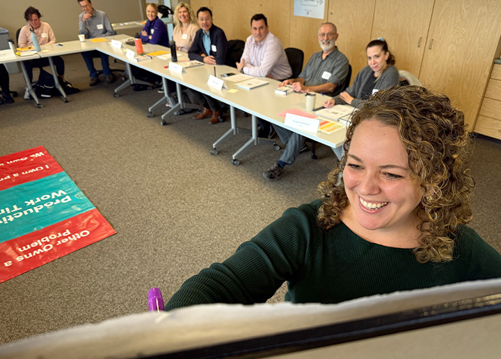 An instructor at a white board teaches an Excellence in Leadership session.