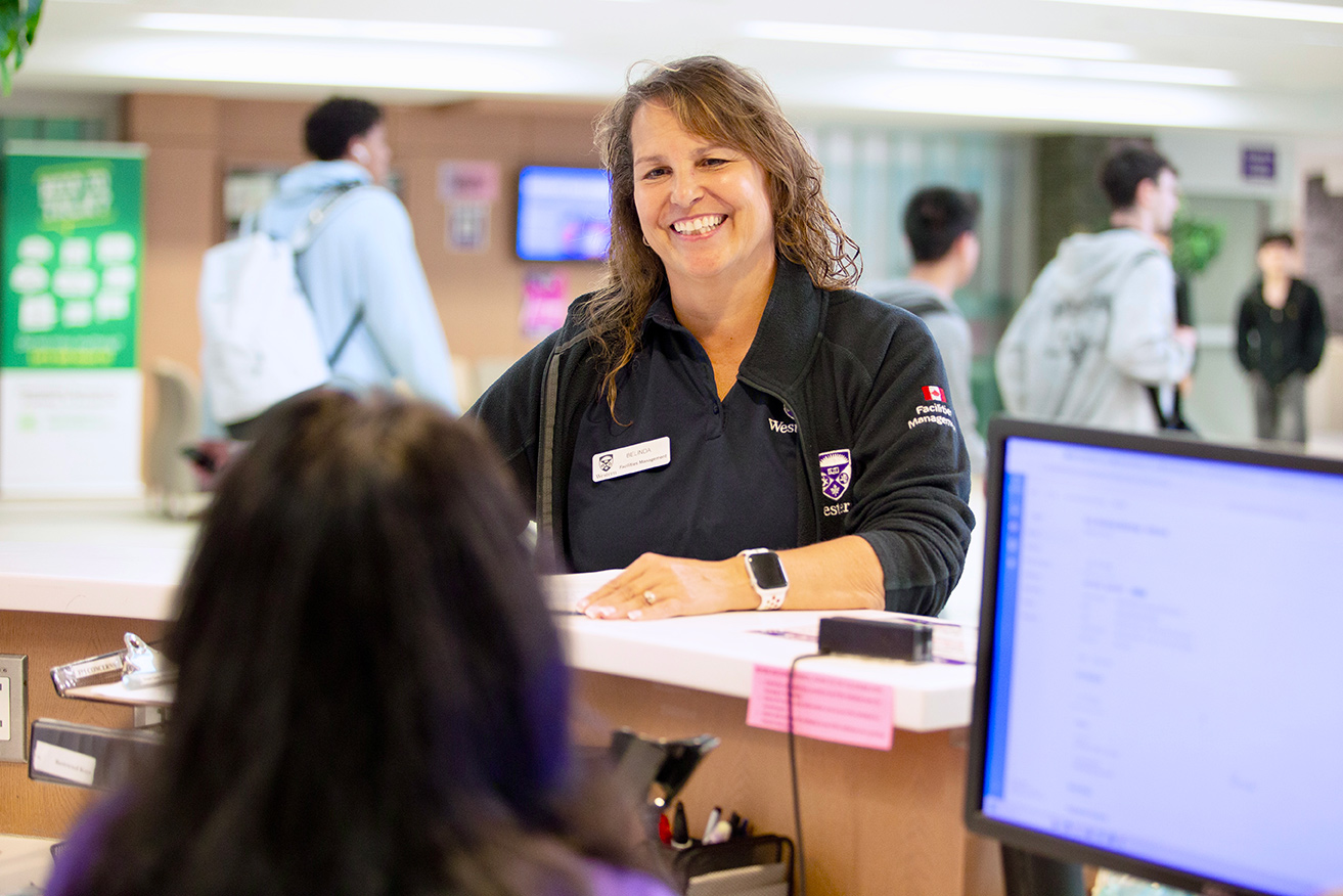 Caretaker Belinda Couto chats with a front desk colleague in Ontario Hall.