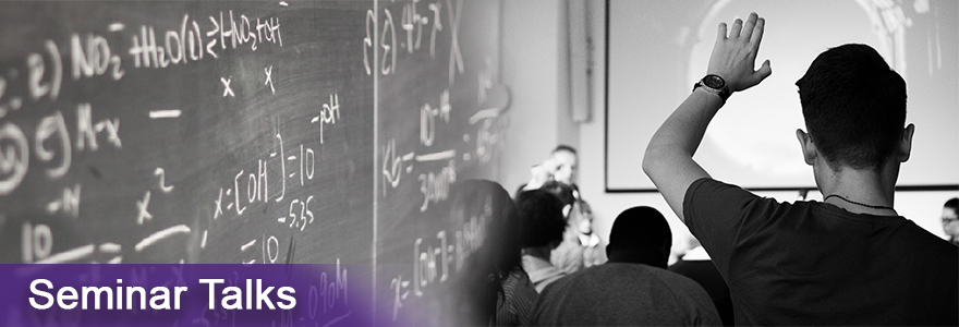 Chalkboard equations and person with their hand up to ask a question