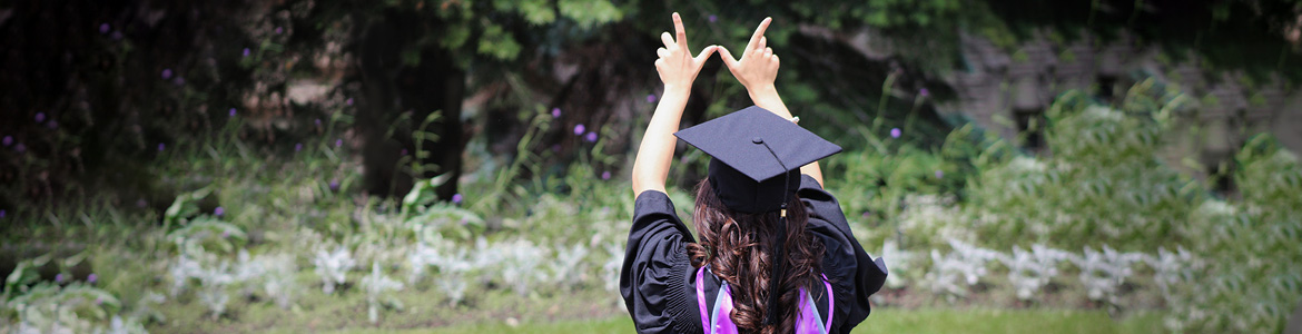 Graduate holding fingers in W shape