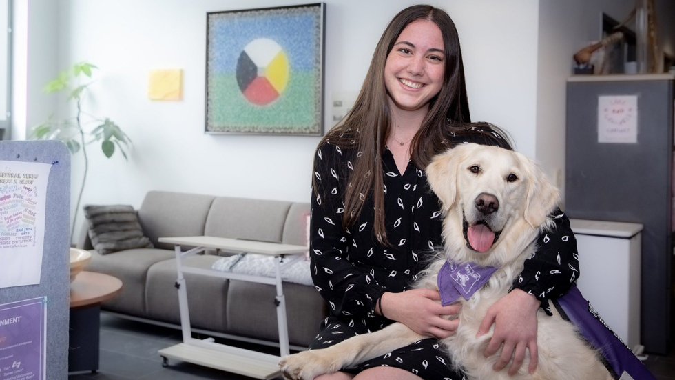 Grad Alyssa Harvey huggin a dog