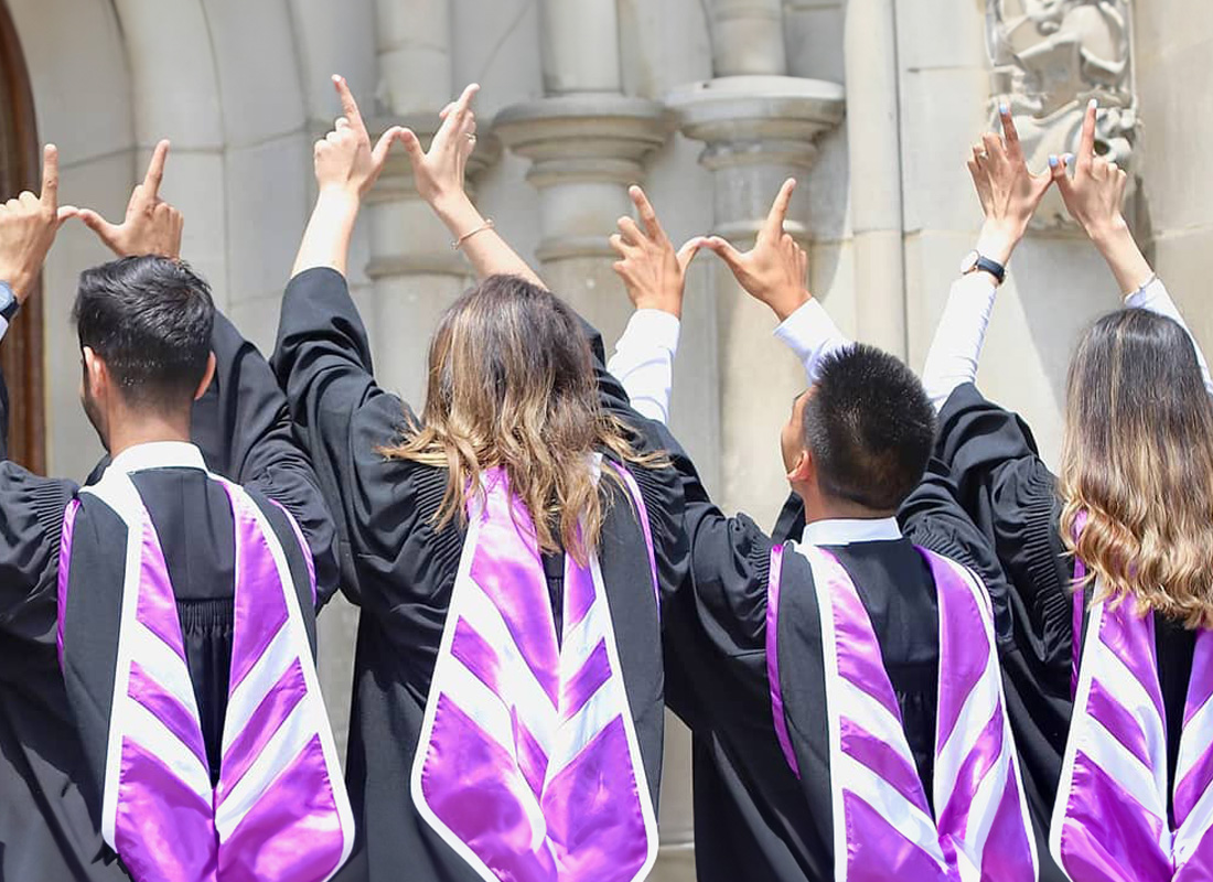 Students with their back turn throwing up Western W hand sign 