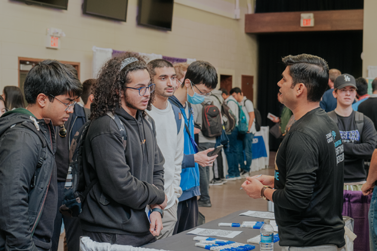 Students networking with an employer