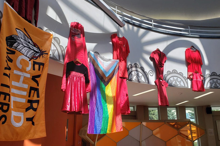 Red dresses hanging in Wampum Learning Lodge