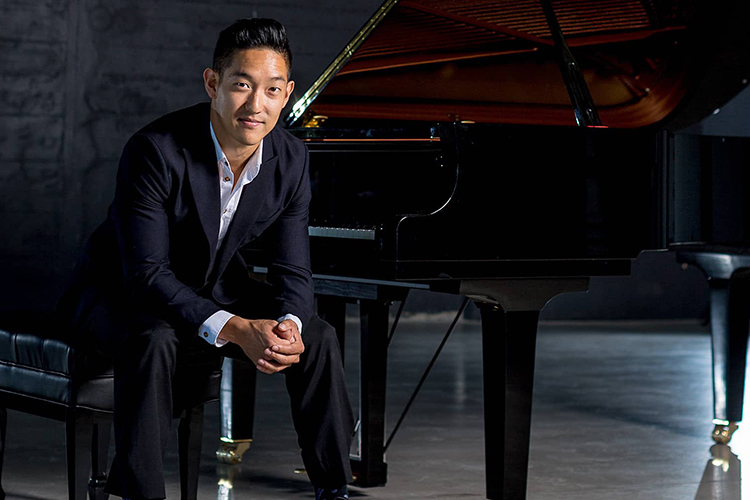 John Yun seated at a piano