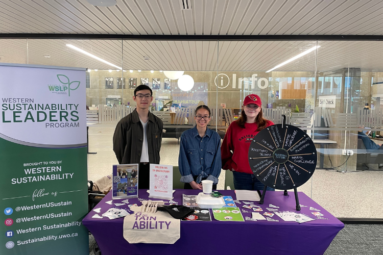 Three students standing at the Sustainability booth