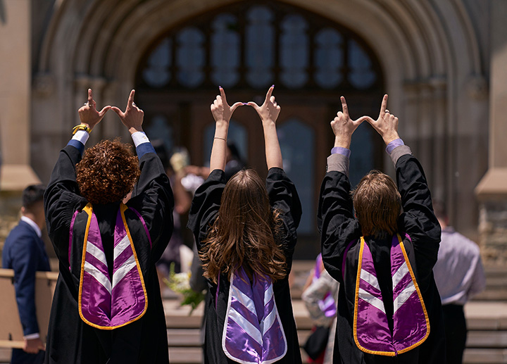 Students at convocation holding up their hands to make a Western 'W'.