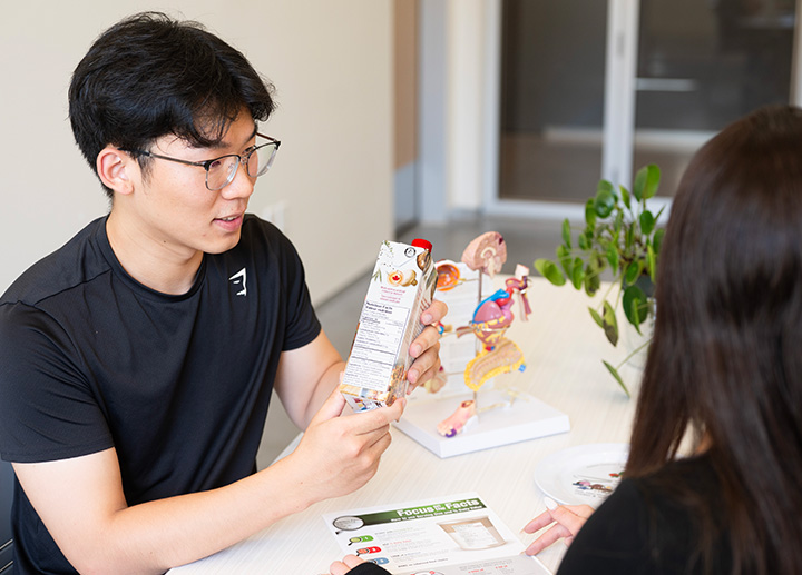 A foods student reviewing nutrition facts on a product label.