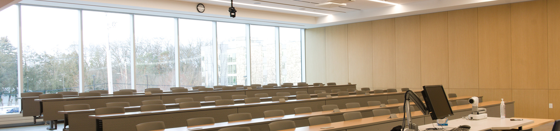 A classroom inside the teaching facilities, featuring floor-to-ceiling windows across the back.
