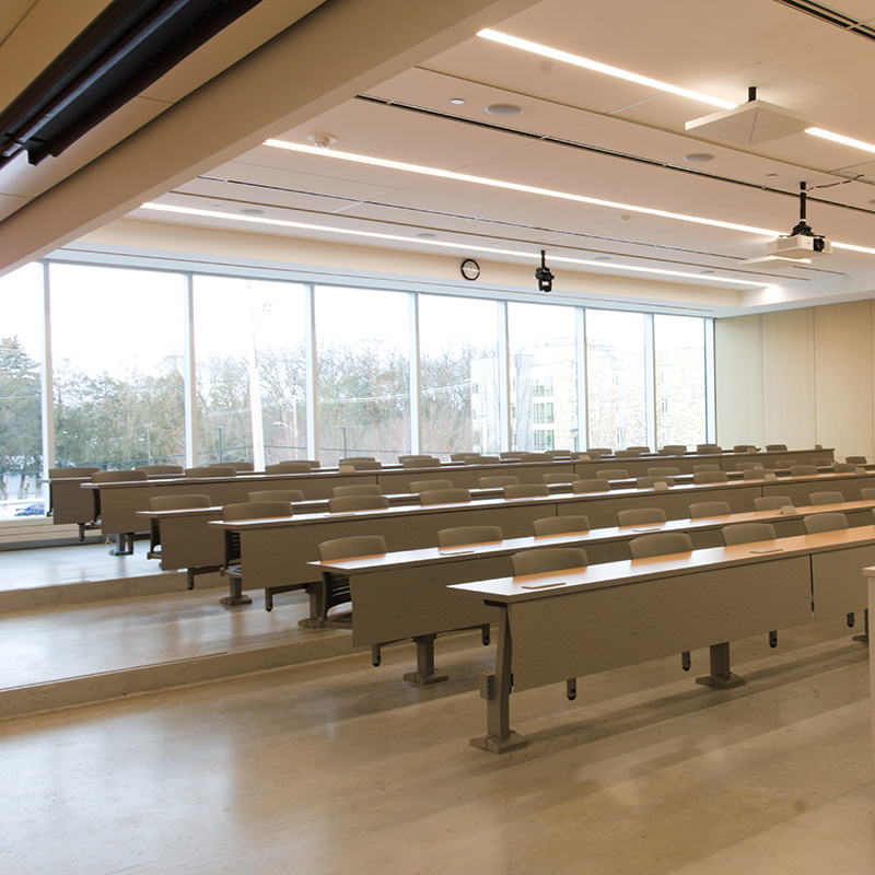 A classroom inside the teaching facilities, featuring floor-to-ceiling windows across the back.