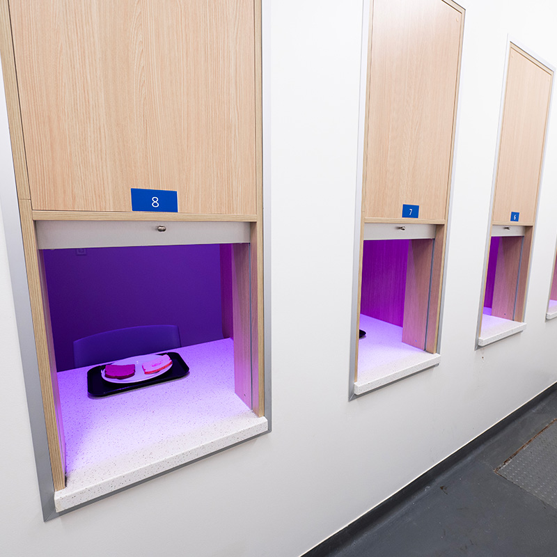 A side-by-side of two photos from the sensory lab; one with the lighting set to a vibrant pink, and the other with standard lighting.