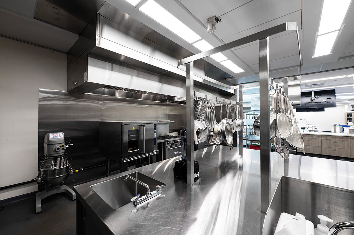 A closeup of pots and pans hanging up in the commercial kitchen.