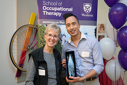 Lynn Shaw presents an award to Adam Ly