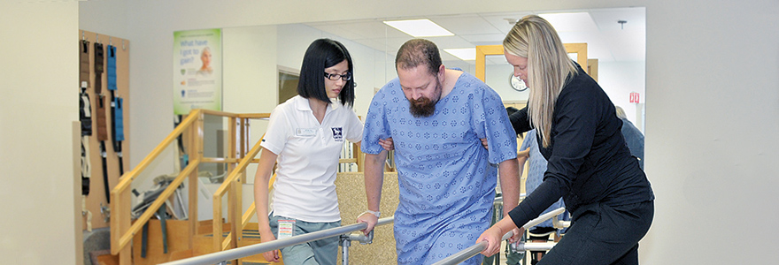 two students helping a man walk