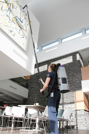 Caretaker using the backpack vacuum with space vac extension