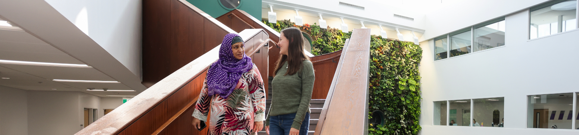 Two women descend stairs in Thames Hall.