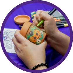 A hand painting a potted plant.