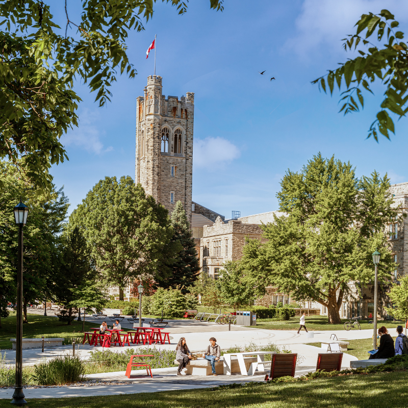 students walking on campus, outside UC tower on a sunny day.