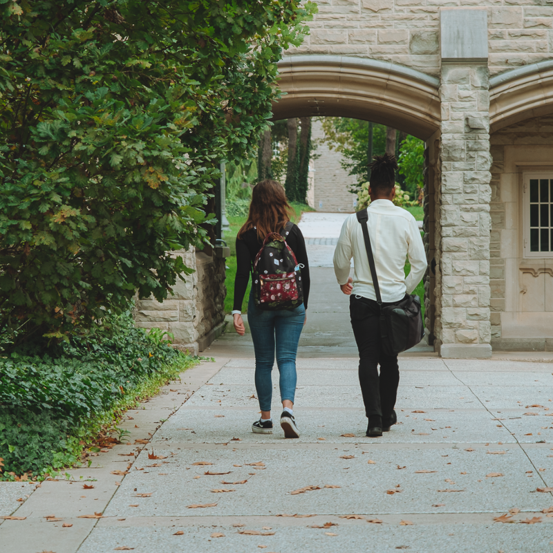 Two people walking on campus.