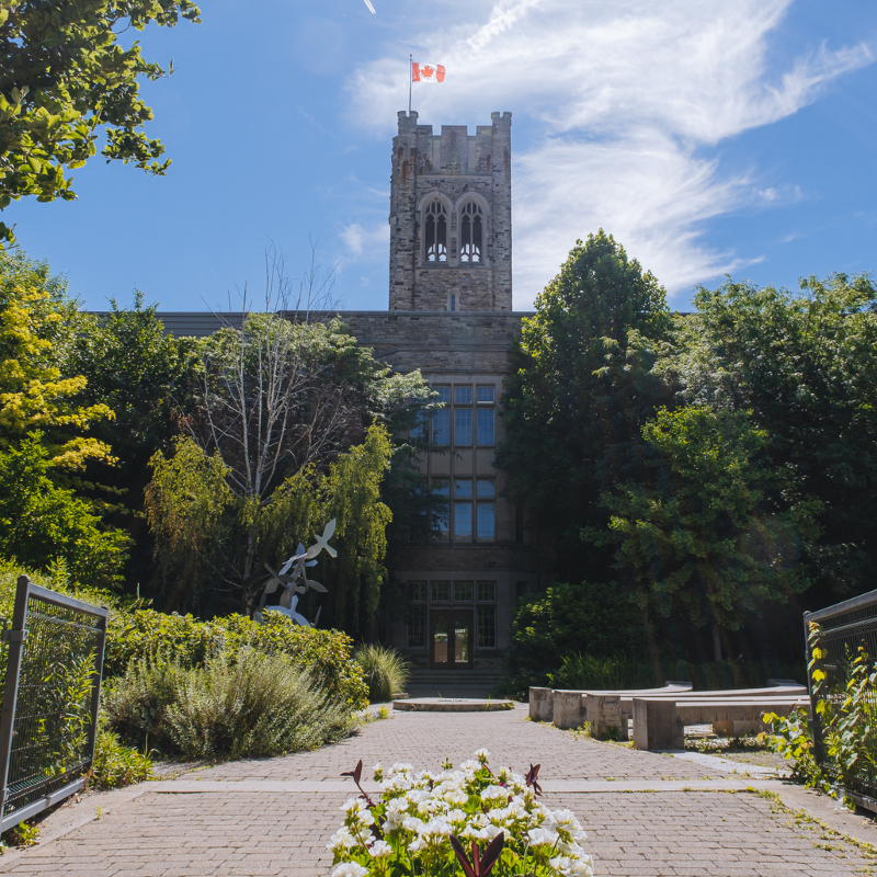 A photo of a garden in front of University College tower.