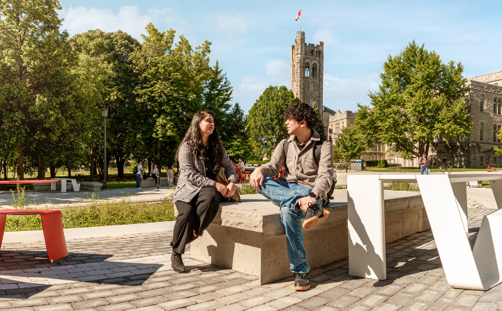 Two people site in front of University College Tower.