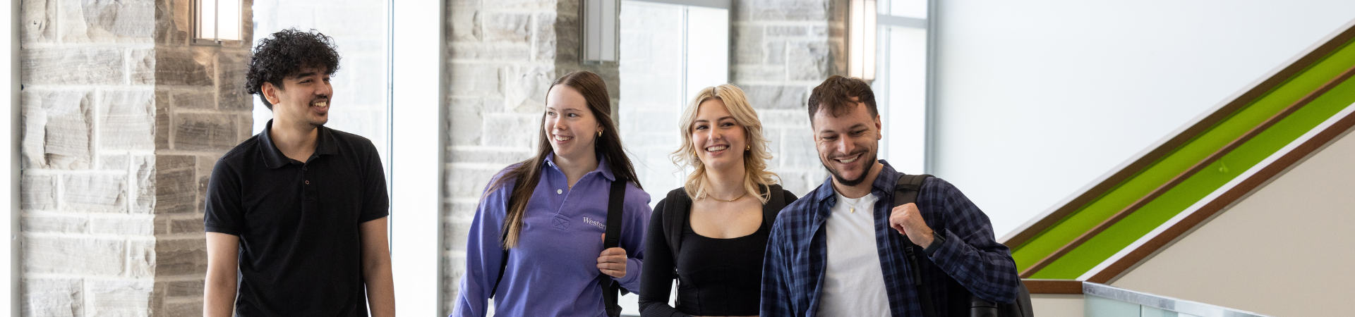 Four students walk inside the nursing building.