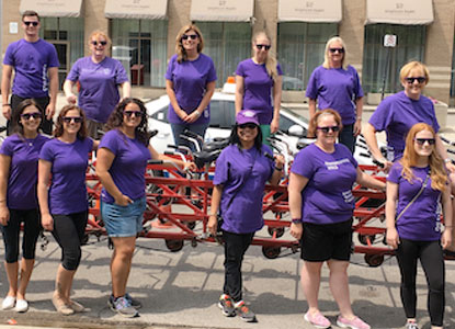 Staff around a giant team-powered bicycle