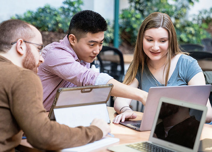 Students pointing to a laptop