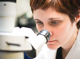 female student looking into a microscope